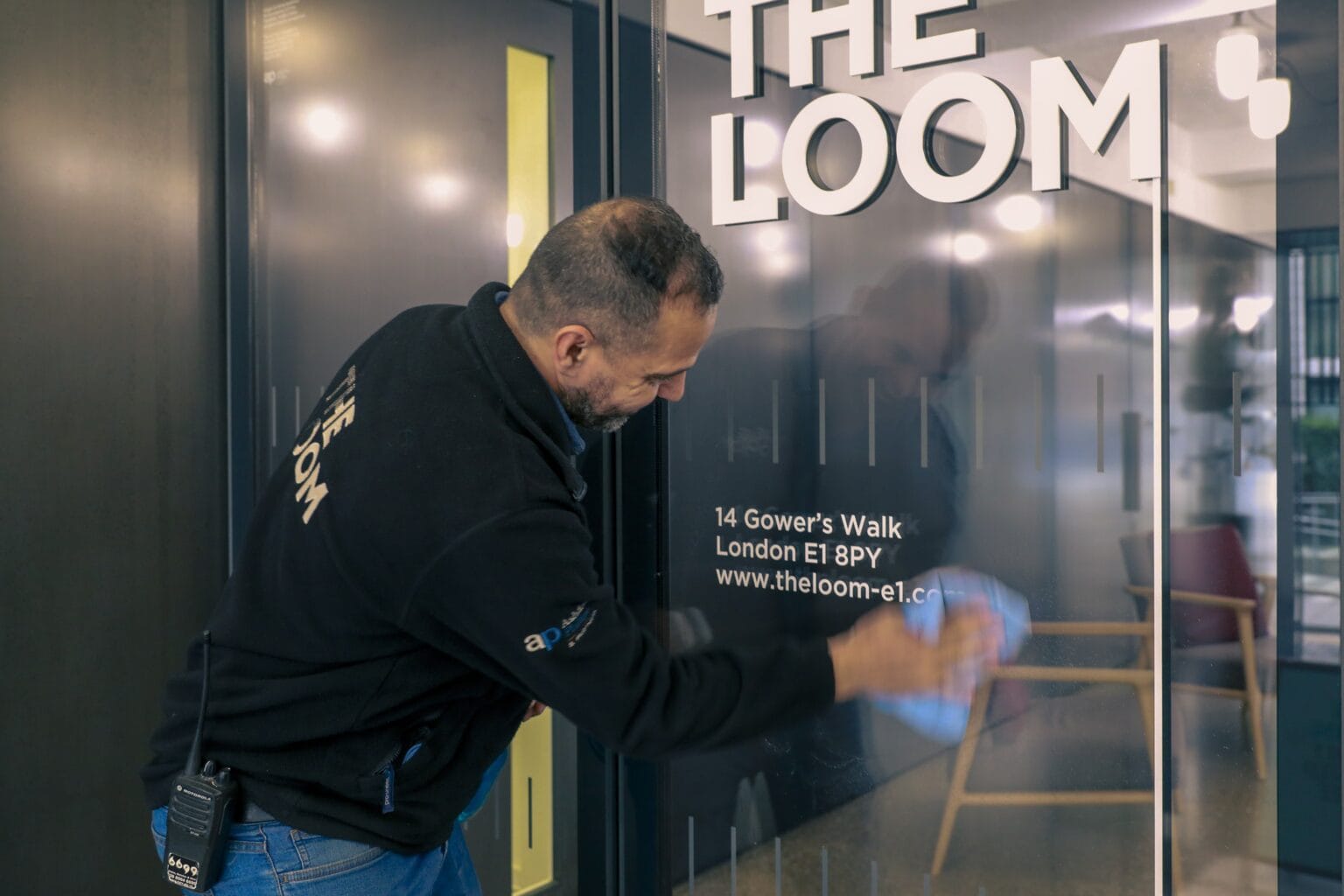 JPC by Samsic cleaner polishing signage at The Loom, London