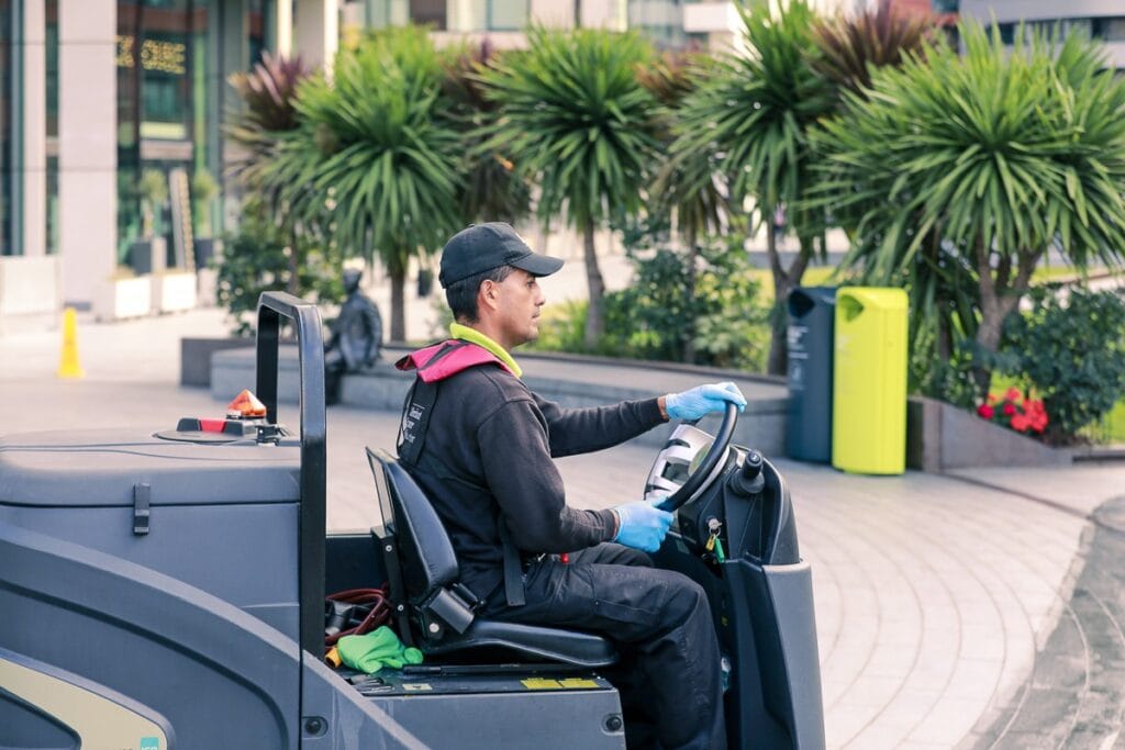 JPC by Samsic operative using a ride-on sweeper on a roof terrace