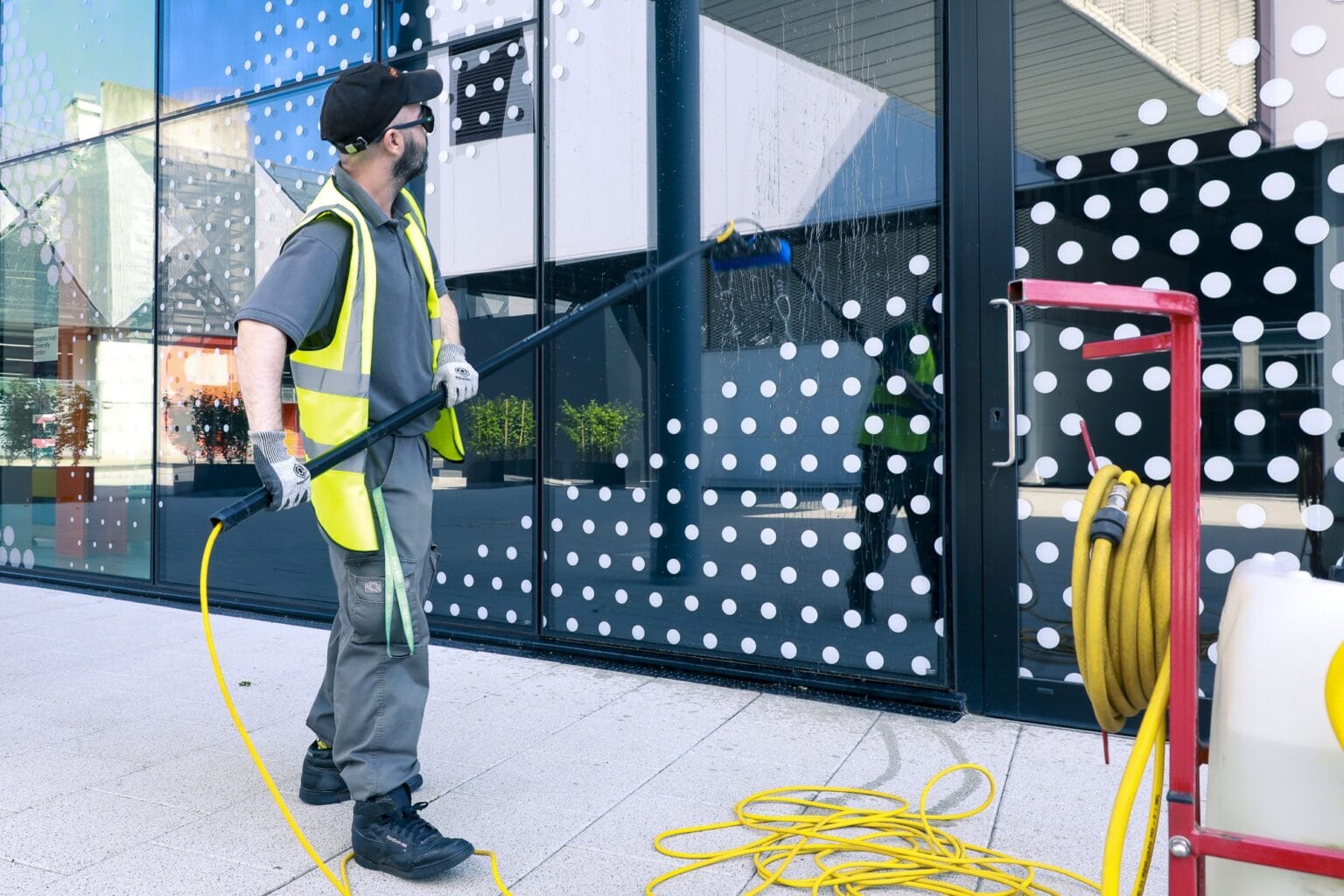 JPC by Samsic cleaner in hi-vis cleaning a building facade